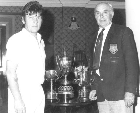 Newry and Mourne Council Chairman Eugene Markey admires the silverware won by Rathfriland Bowling Club secretary Allan Tate. 31706c